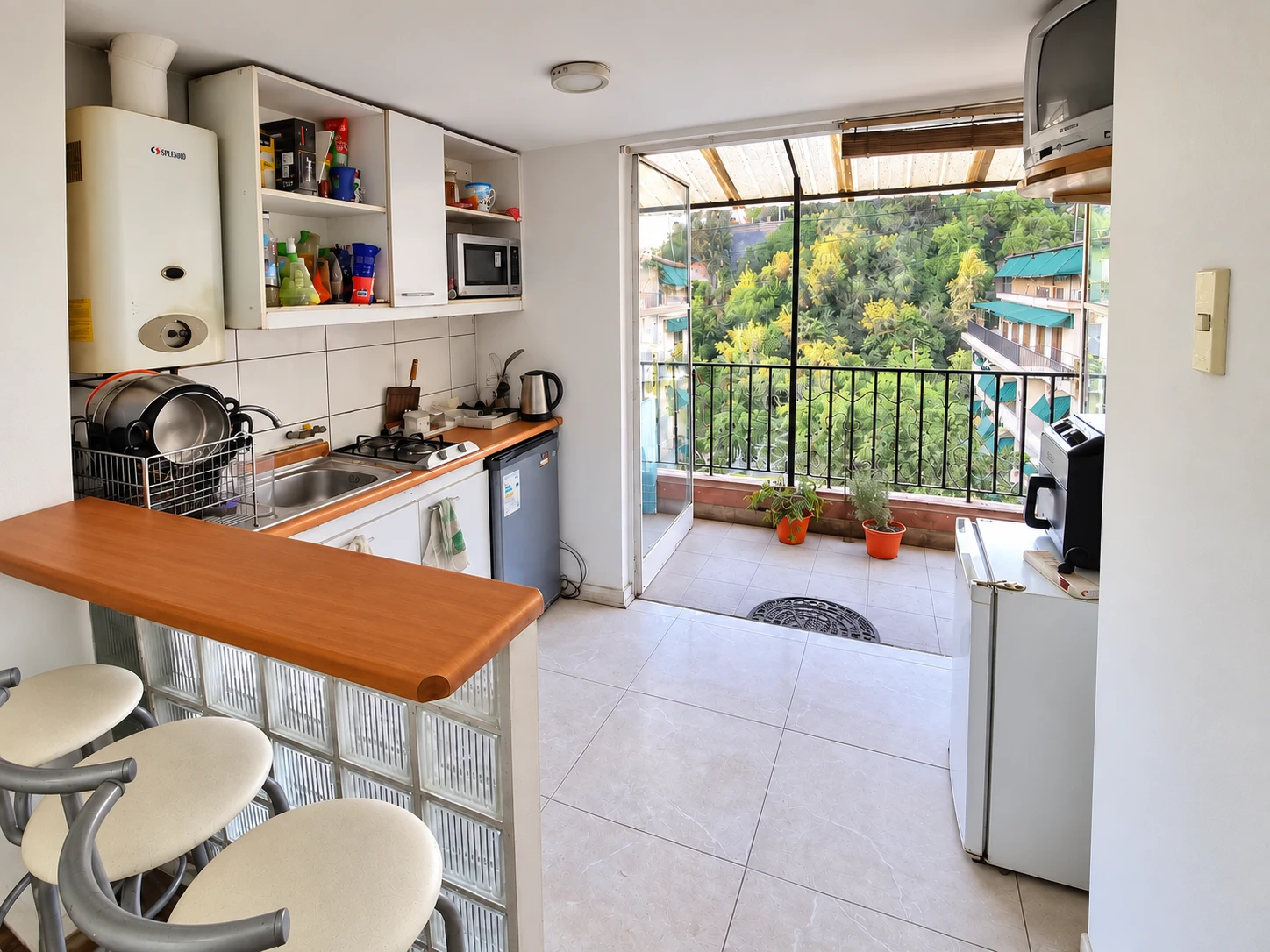 Cocina compartida del departamento 82, con barra y salida a la terraza